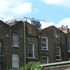 The gleaming extension facade reflects the sky